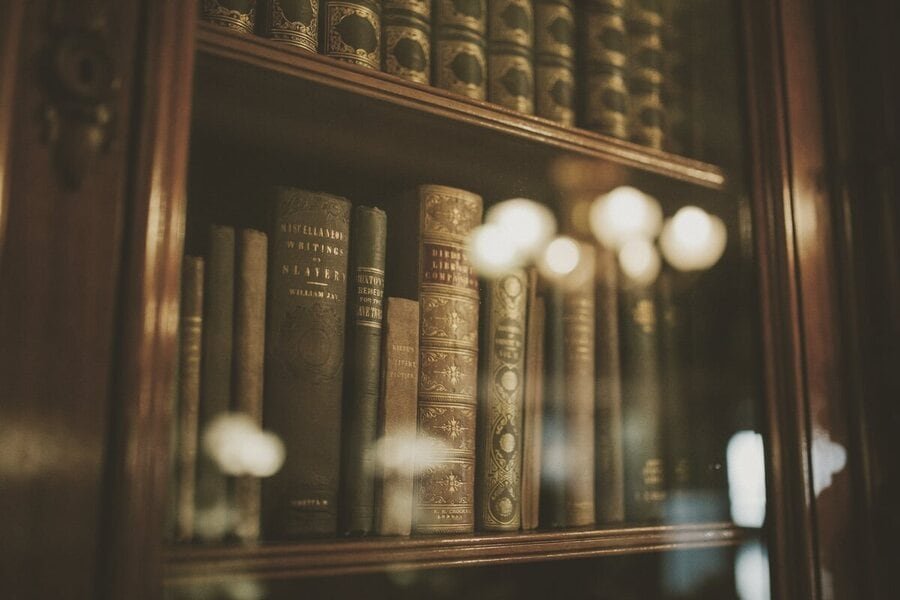 Estante antiga com códigos e livros de direito atrás de uma porta de vidro