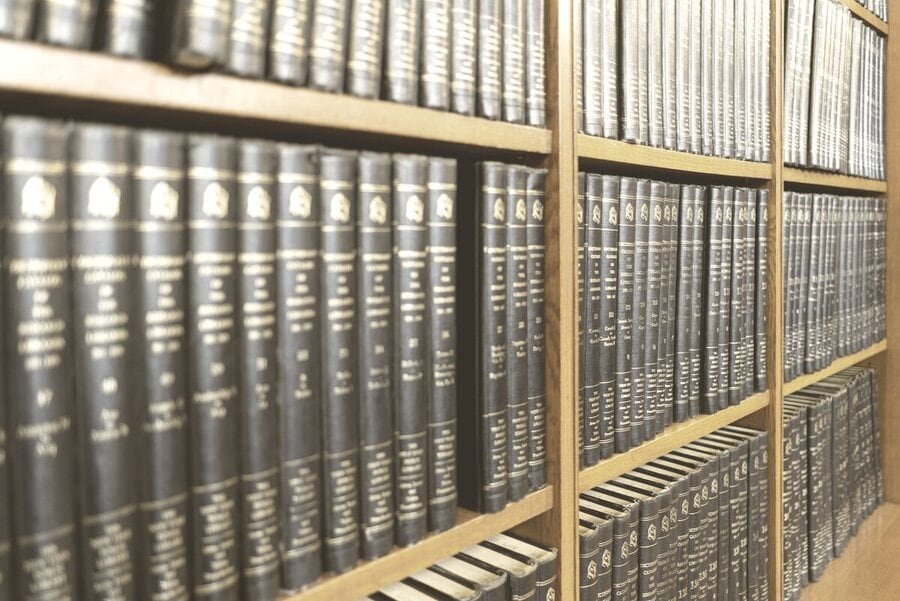 Prateleiras de uma biblioteca jurídica com volumes de jurisprudência encadernados